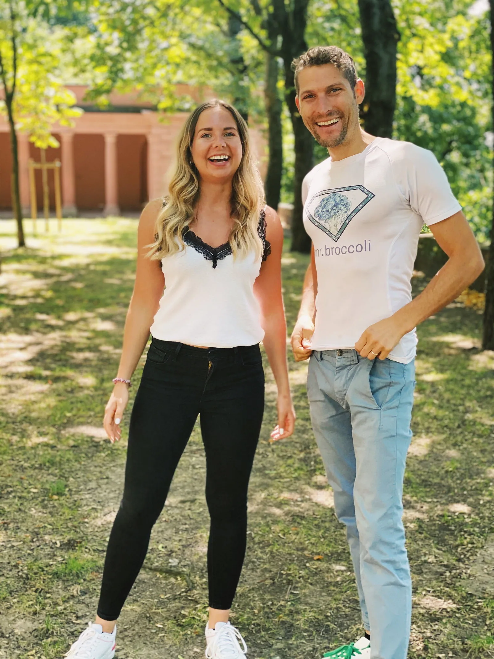 Mann und Frau lächelnd im Park, beide tragen Mr. Broccoli Shirts