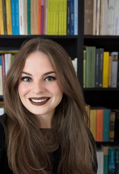 Porträt Janin Pisarek, Frau mit braunen Haaren vor Bücherregal