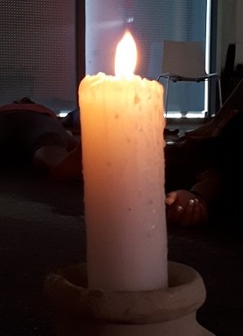 Brennende weiße Kerze mit gelbem Licht, Symbol für Lebenskraft und Spiritualität