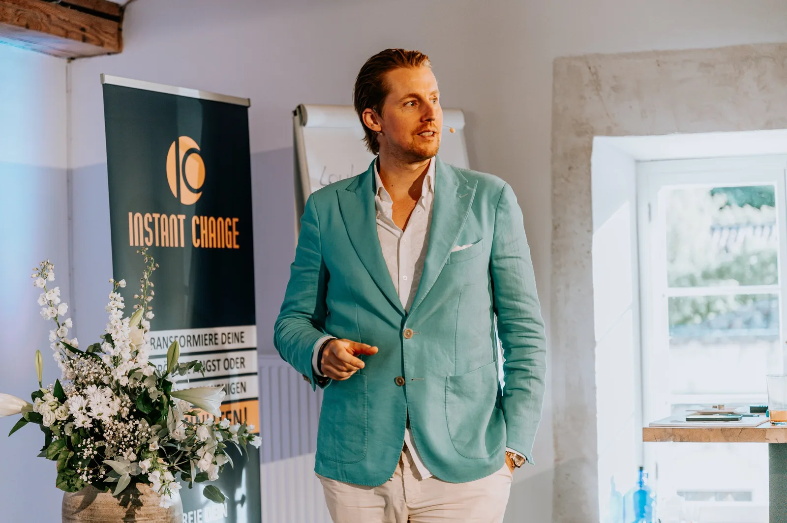 Mann in türkisem Blazer präsentiert Instant Change Logo auf Präsentationsboard
