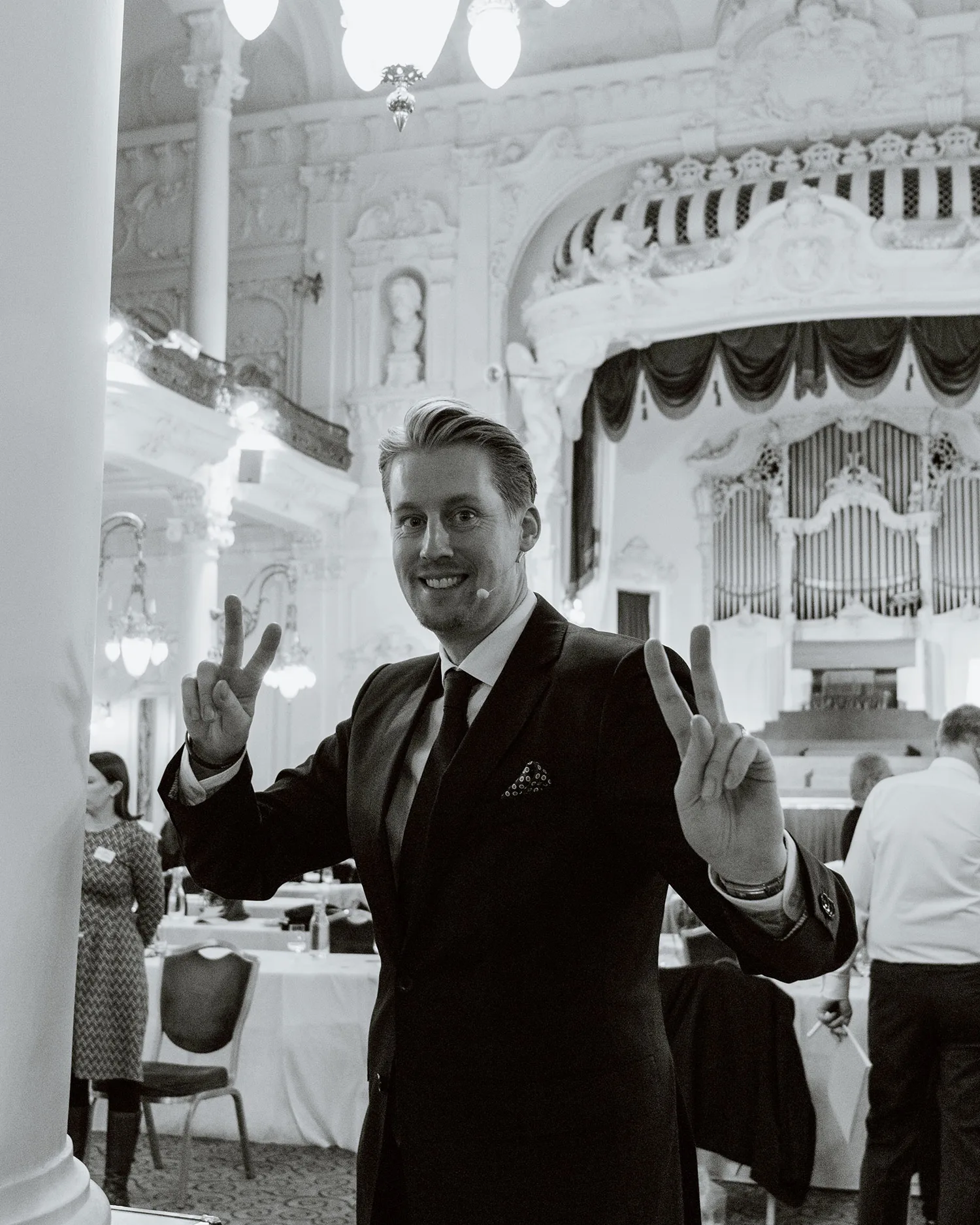 Daniel Weinstock in Anzug und Krawatte in eleganten Ballsaal, schwarz-weiß Fotografie