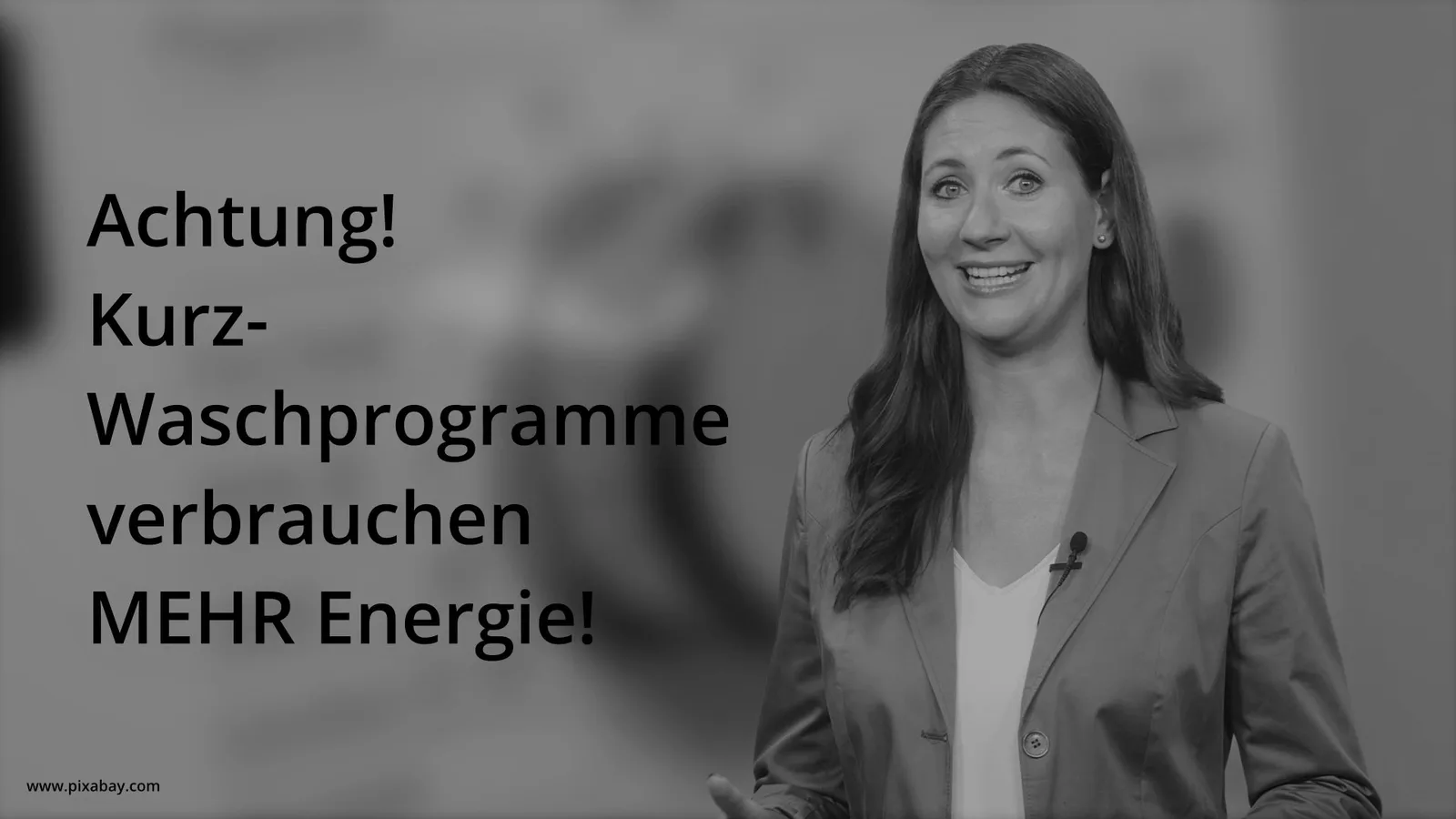 Schwarz-weiße Videostandbild einer lächelnden Frau mit Text "Achtung! Kurz-Waschprogramme verbrauchen MEHR Energie!"