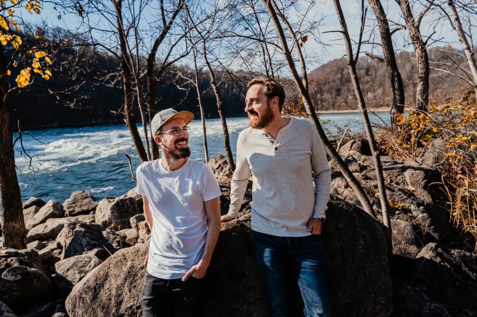 Zwei Männer an Flusslandschaft mit wärmeren, gesättigteren Farben, bearbeitete Reisepreset-Version