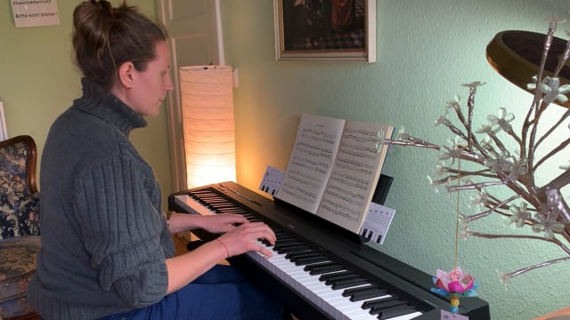 Frau spielt Klavier mit Notenblättern, Musikunterricht zu Hause