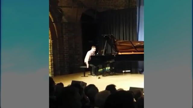 Pianist spielt auf Flügel auf Bühne vor Publikum bei Konzertauftritt