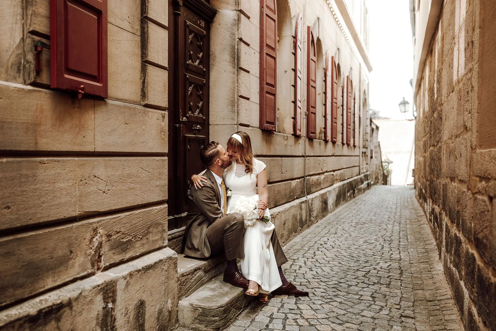 Hochzeitspaar in Altstadt-Gasse, sitzend, romantische Szene, historische Architektur