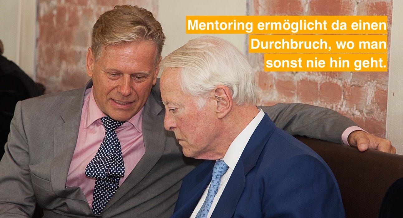 Zwei Geschäftsmänner beim Mentoring mit Zitat: Mentoring ermöglicht da einen Durchbruch, wo man sonst nie hin geht