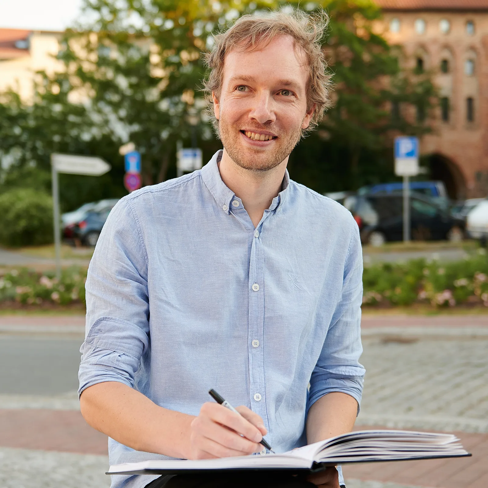 Porträt von Maxim Simonenko beim Zeichnen mit Skizzenbuch im Freien