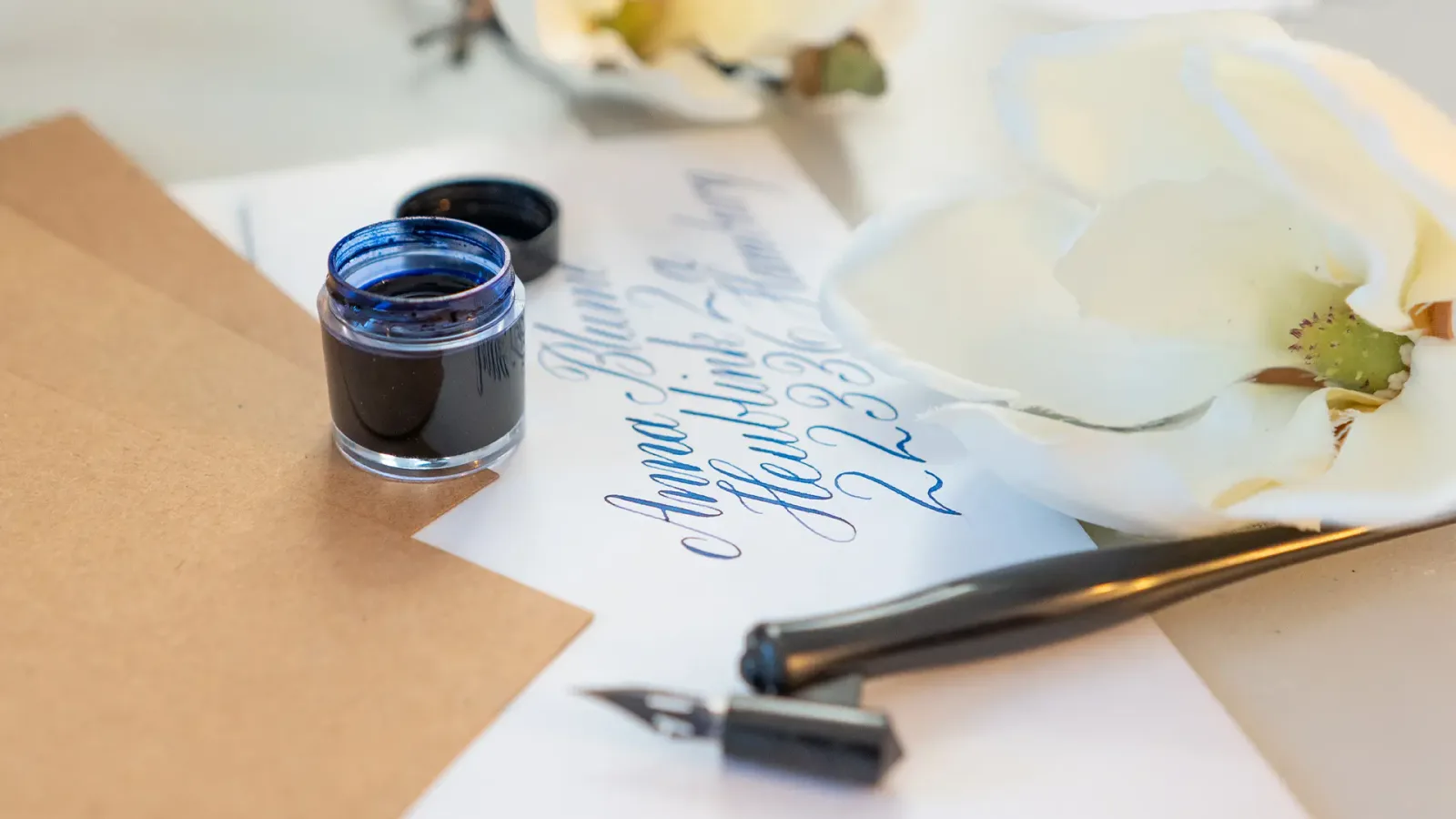Detailaufnahme von Kalligrafie-Schreibweise mit beschrifteter Feder und Bewegungsanweisungen