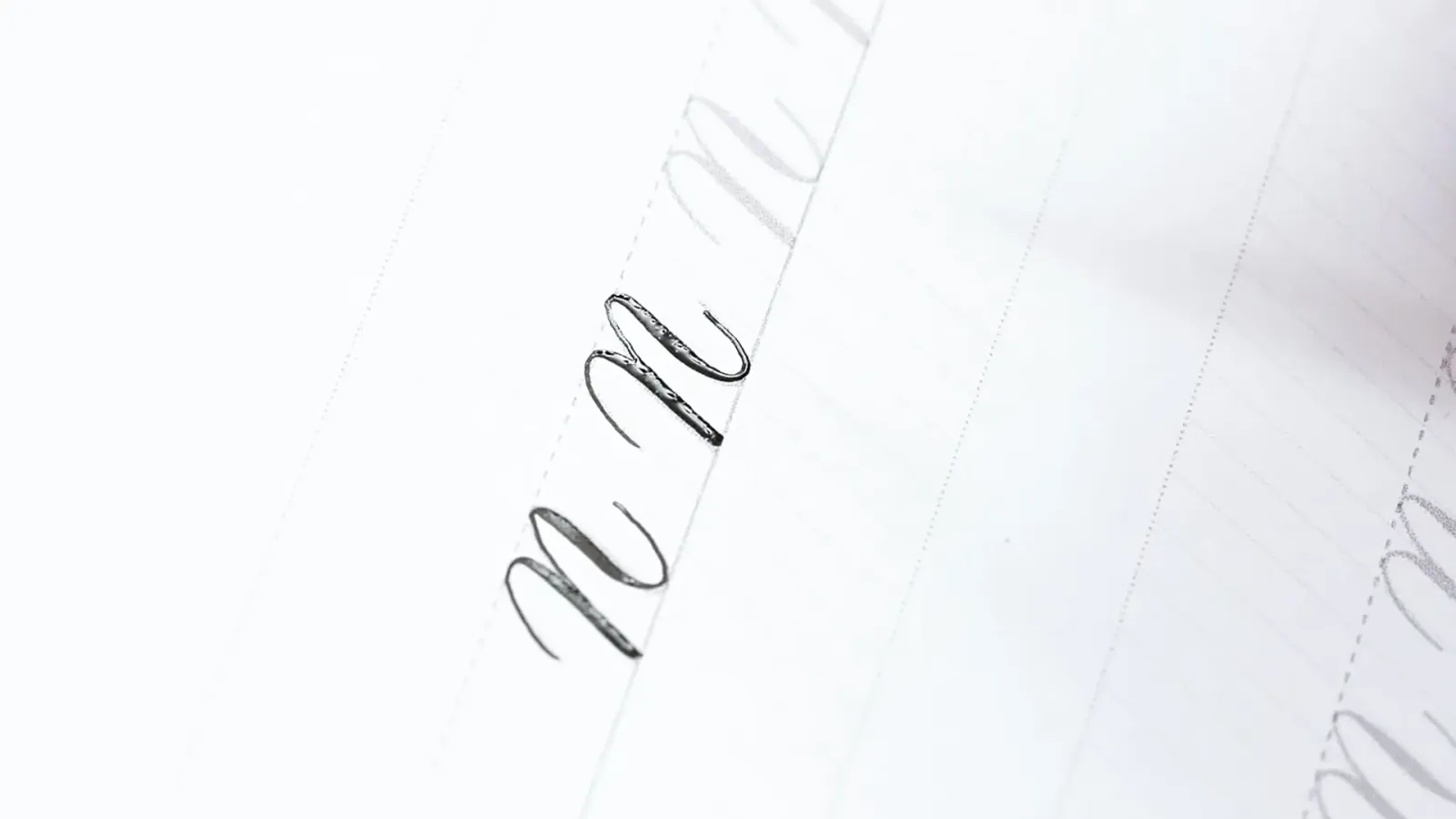 Übungen zu Kalligrafie-Kleinbuchstaben mit Federn auf Papier