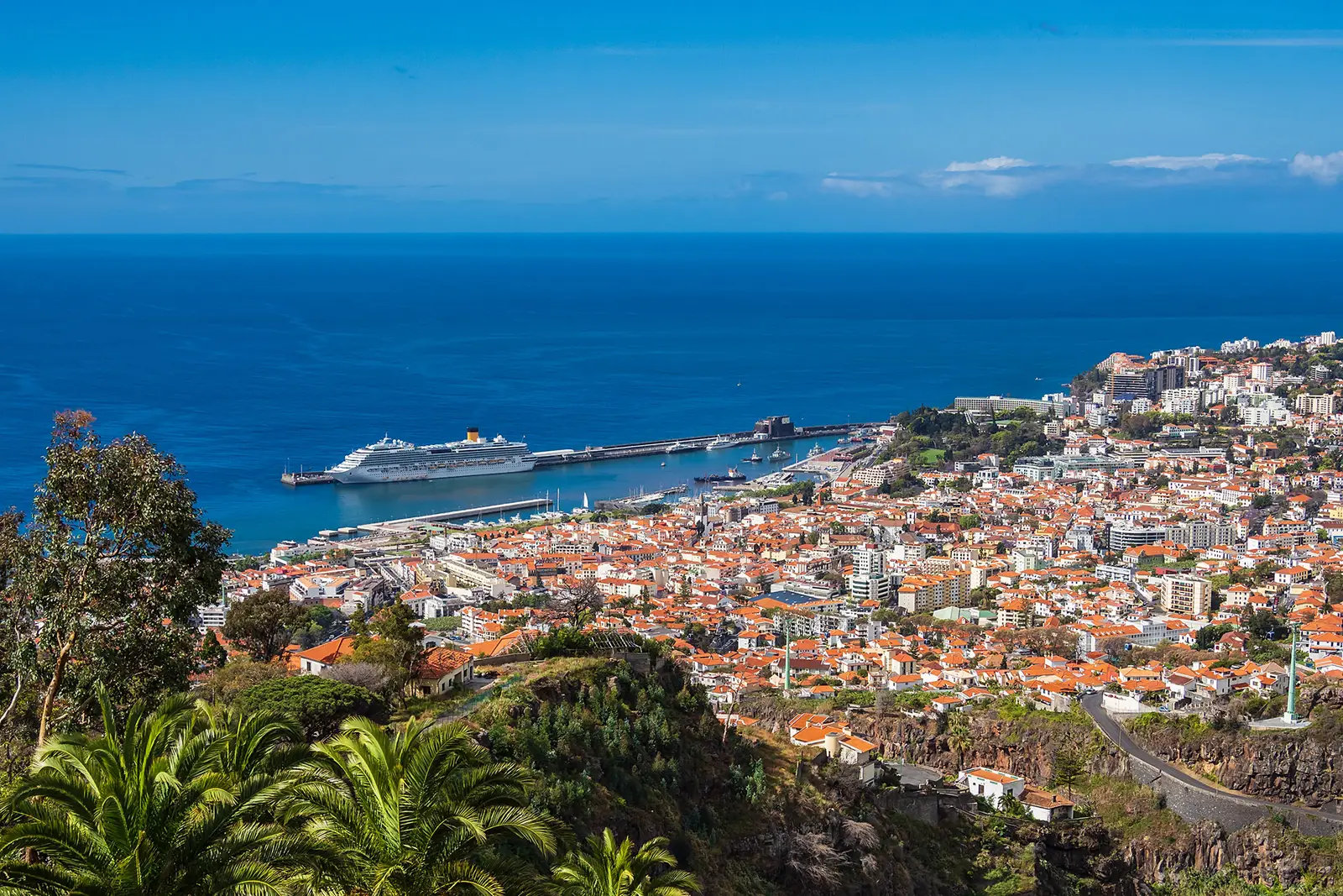 Kreuzfahrtschiff im Hafen von Funchal, Madeira, umgeben von Altstadt mit Ziegeldächern