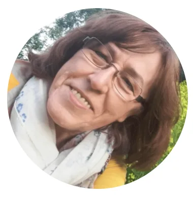 Irene, Frau mit braunem Haar und Brille, rundes Portraitfoto