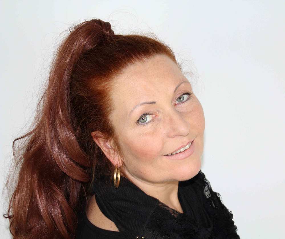 Porträtfoto von Monika Baumgarth mit rötlich-braunem Haar