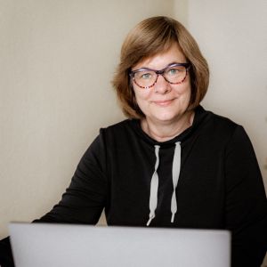 Sabine Omarow, Frau mit Brille am Laptop, schwarzer Hoodie