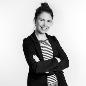 Mara Walch, Frau mit schwarzem Blazer und gestreiftem Shirt, Arme verschränkt