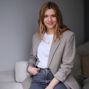 Frances Gallert, Frau im beigen Blazer mit weißer Tasse