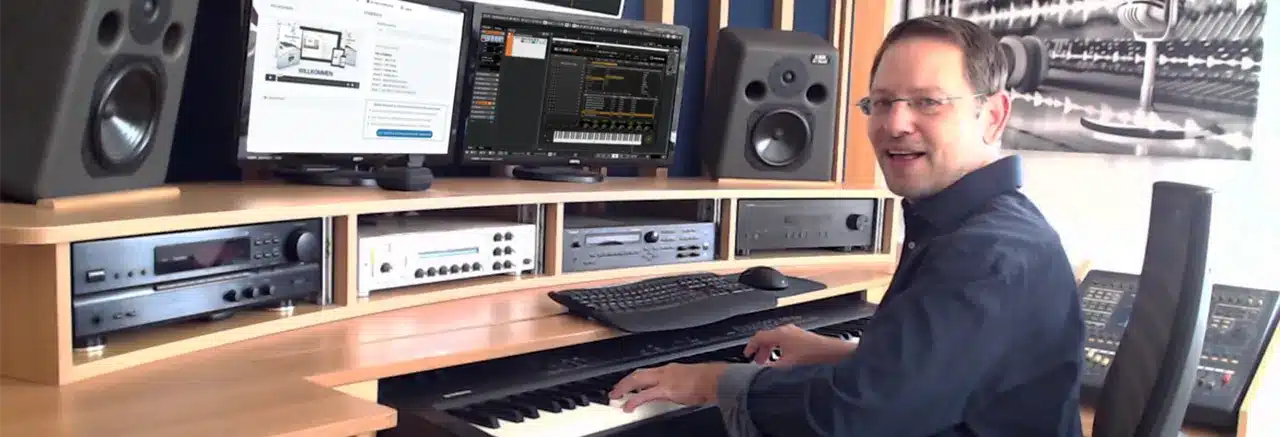 Klassische Musik I – Klavierkurs für Klassik von Roman Sillipp 5 Roman Sillipp sitzt am Klavier vor Musikstudio-Ausrüstung und Computermonitoren mit Produktwebsite