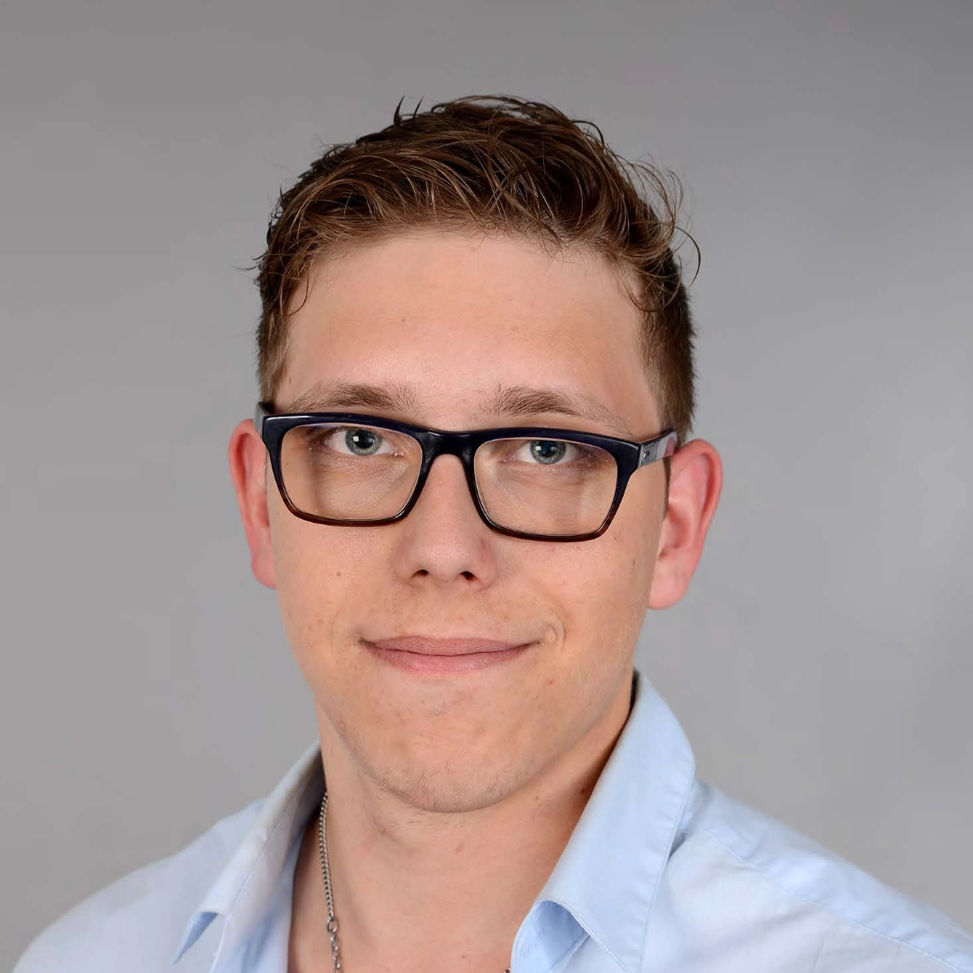 Porträtfoto eines Mannes mit Brille in hellem Businesshemd
