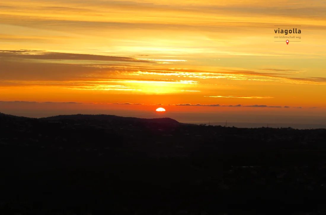 Sonnenuntergang über französischer Berglandschaft mit viagolla Logo