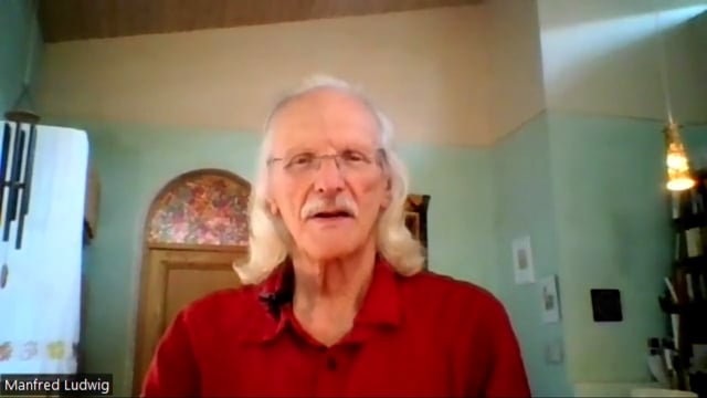 Kongresspaket 149.PLUS – Videokurs zur Langlebigkeit 3 Videostandbild von Manfred Ludwig, älterer Mann mit Schnurrbart in rotem Hemd vor grüner Wand