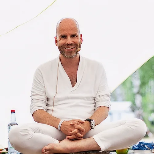 Kongresspaket Entdeckerin: Abzocke – Kurs zu spiritueller Abzocke 22 Porträtfoto von Tim Taxis in weißem Leinenhemd, sitzt meditierend