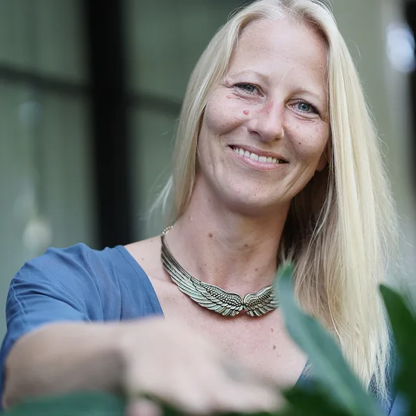 Kongresspaket Entdeckerin: Abzocke – Kurs zu spiritueller Abzocke 15 Porträt von Jennifer, blonde Frau mit blauem Oberteil und silbernem Flügel-Halskettchen