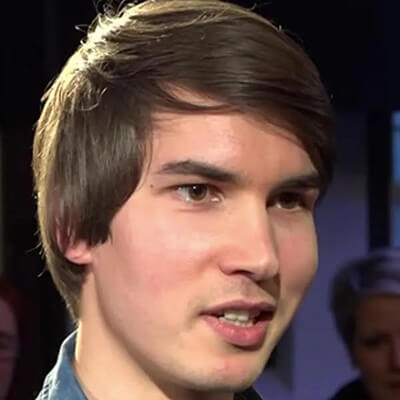 Junger Mann mit dunklem Haar, Seitenprofil vor dunklem Hintergrund