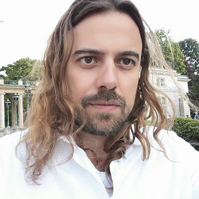 Jan Walter, Mann mit langen braunen Haaren, weißem Hemd, vor klassischer Architektur