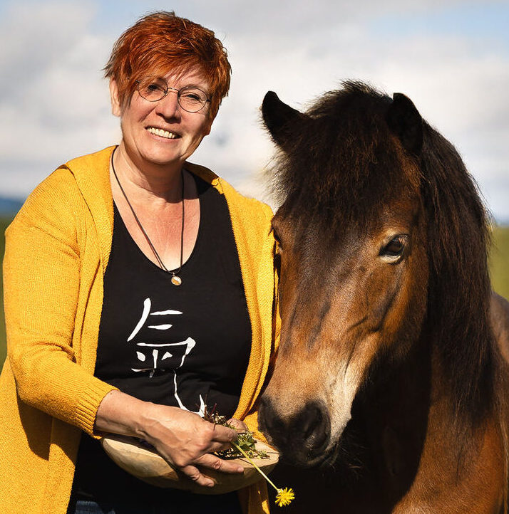 Stephanie Reineke mit braun-schwarzem Pferd, Weidenblatt in der Hand