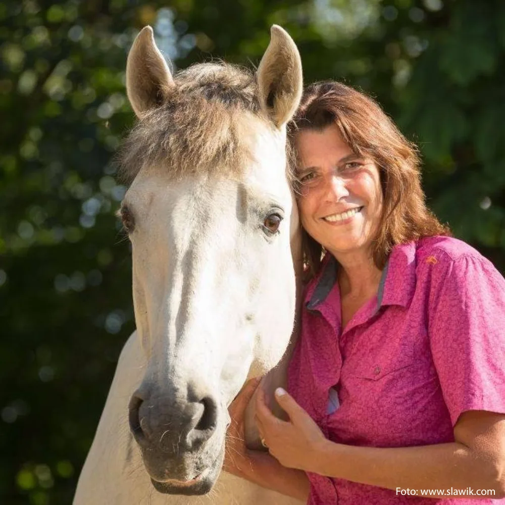 Claudia Sanders mit weißem Pferd, pink Shirt, Pferdetrainerin