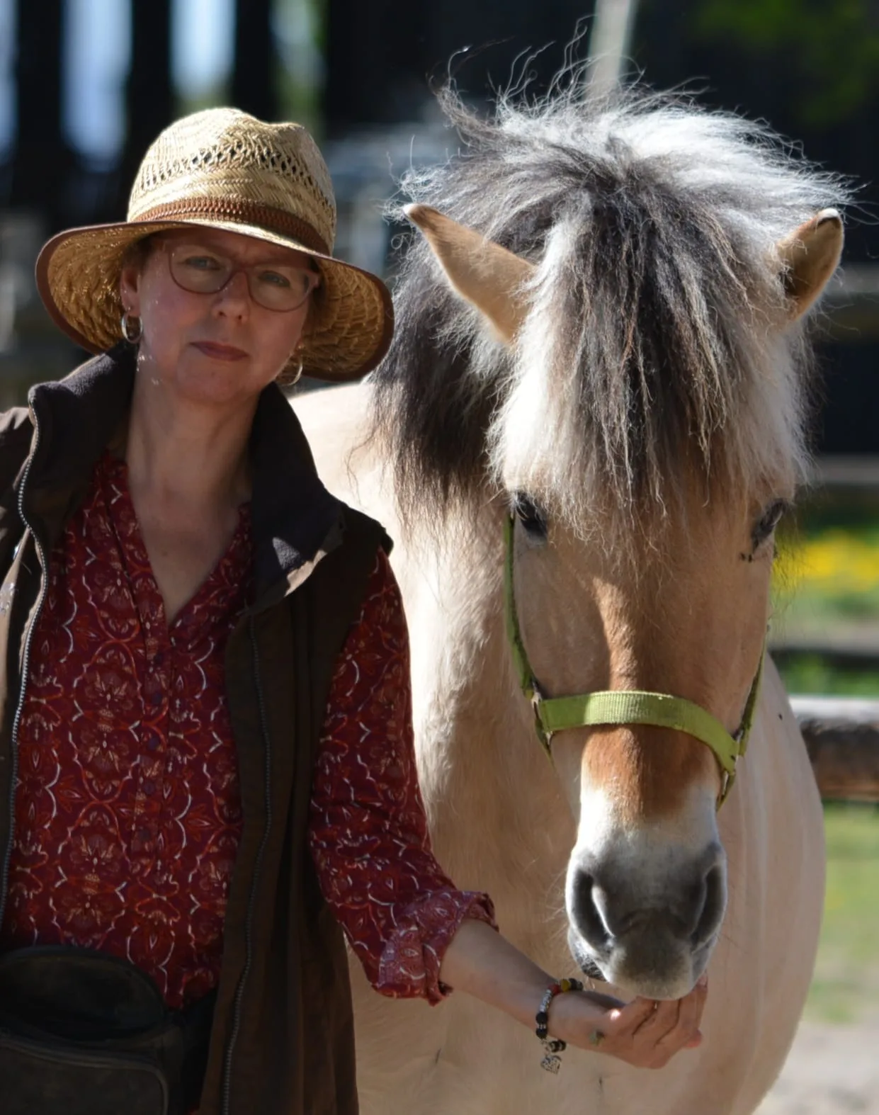 Daniela Bolze mit Pferd, Frau mit Strohhut und Brille neben Pferd mit weißer Mähne