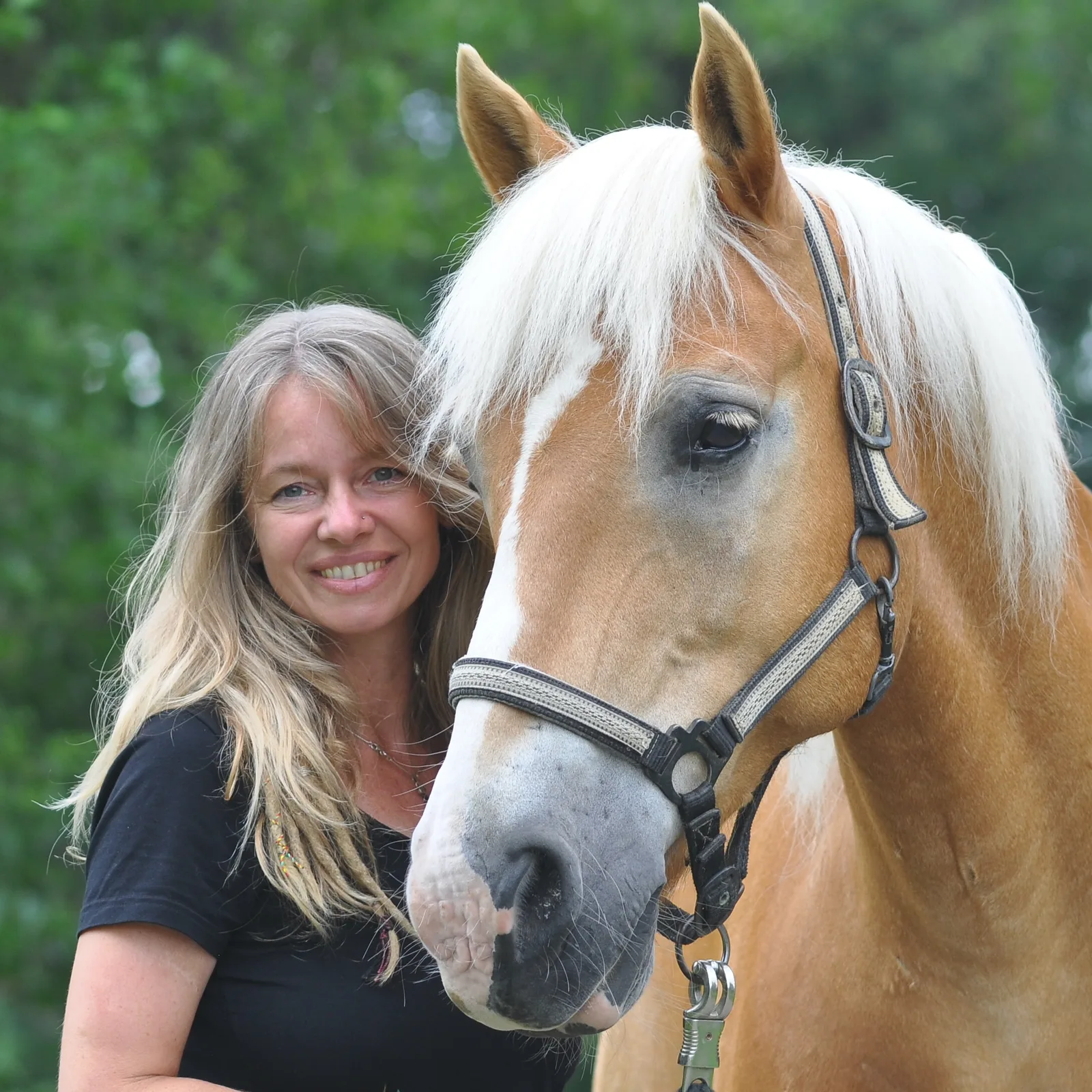 Tania Konnerth mit Pferd, schwarzes T-Shirt, braunes Pferd mit weißem Blesse