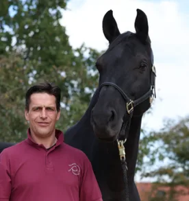 Ralf Döringshoff mit schwarzem Pferd, Porträt im Freien