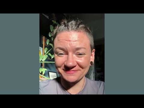 Körperaufrichtung – Energie-Coaching per Zoom 15 Person mit grauem Haar lächelt vor dunkelgrünem Hintergrund