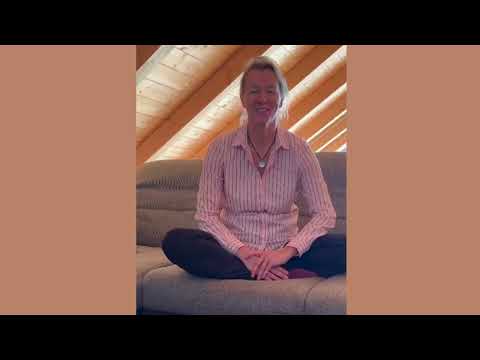 Körperaufrichtung – Energie-Coaching per Zoom 18 Frau in rosa Bluse sitzt auf Sofa in moderner Loftwohnung