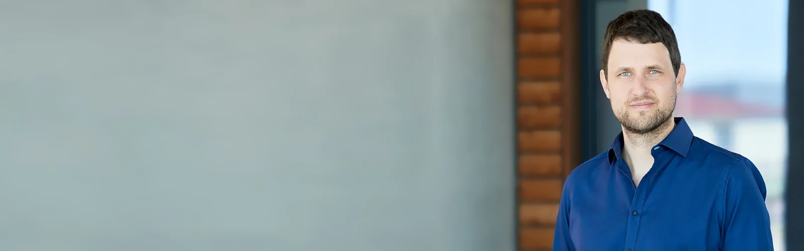 Banner mit Dr. Hendrik Wahler in blauem Hemd vor modernem Hintergrund mit Treppe
