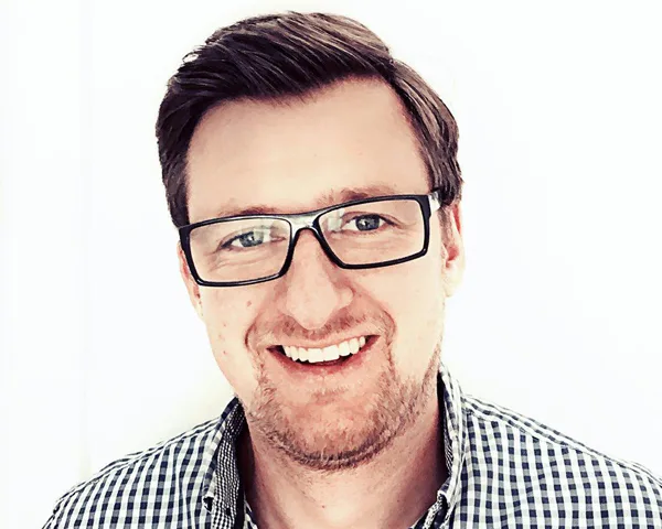 Daniel Rothmund mit Brille, Portrait im Hemd, lächelnd