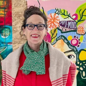 Clara Morgenthau, Frau mit dunklen Haaren und Brille vor buntem Street-Art-Hintergrund