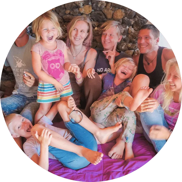 Glückliche Familie mit Kindern beim Spielen auf lila Decke vor Steinwand