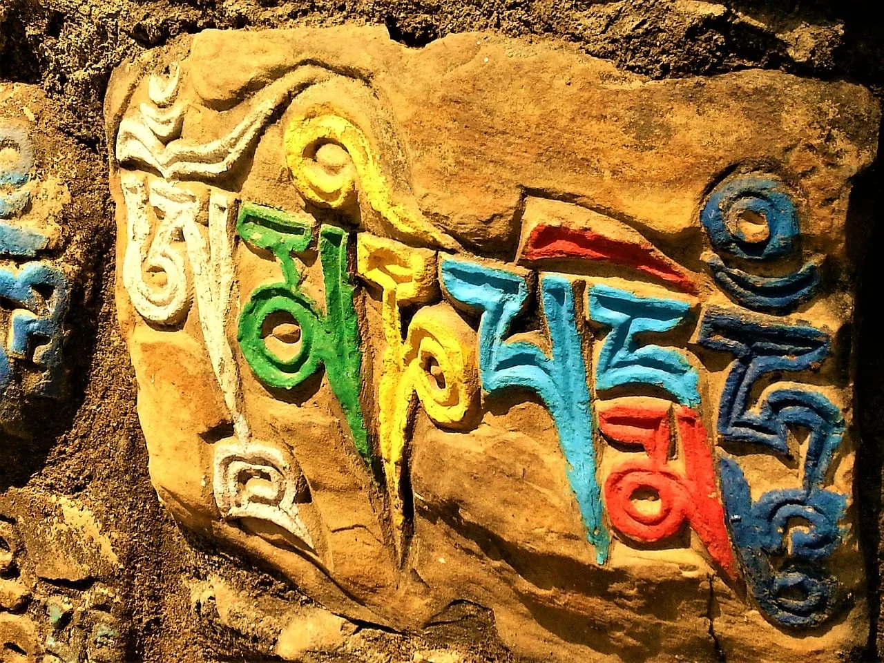 Farbig bemalte Shiva-Skulptur mit Om-Symbol und spirituellen Motiven in Stein