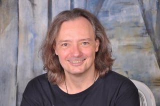 Porträt-Foto von Edgar Hofer lächelnd mit mittellangen Haaren
