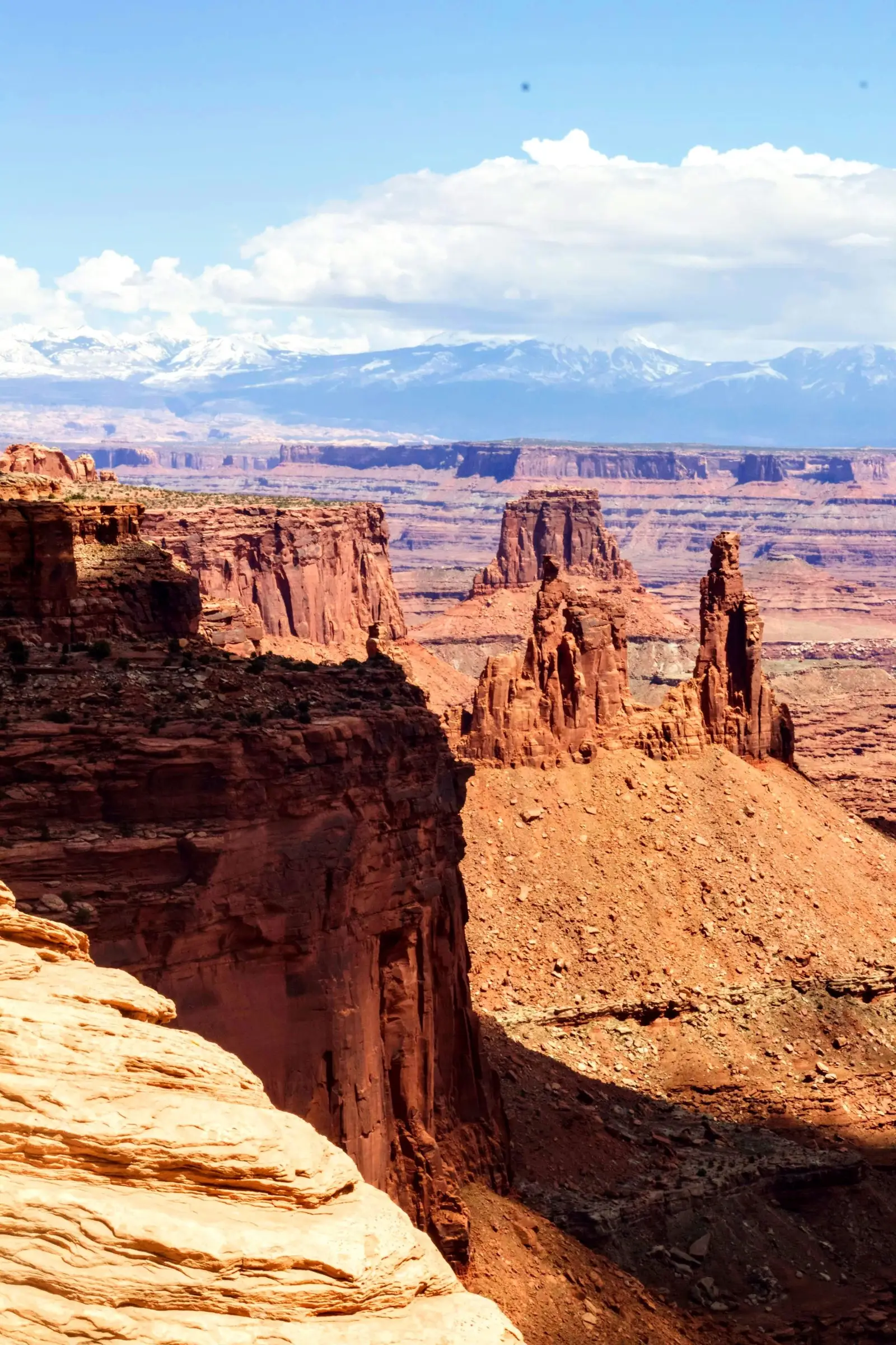 Landschaftsfoto: Canyonlands mit roten Sandsteinklippen, Bergkette, blauem Himmel, Naturinspiration für digitale Malerei