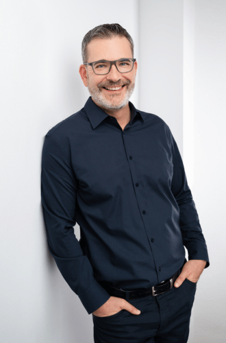 Porträt René Buchinger, Gründer von Gripscoach, in dunklem Hemd vor weißem Hintergrund