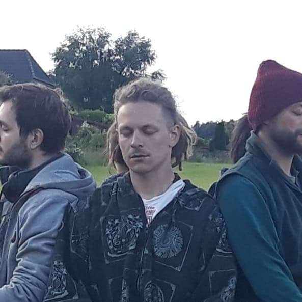 Vier Personen auf Wiese, Person in der Mitte mit blondem Haar
