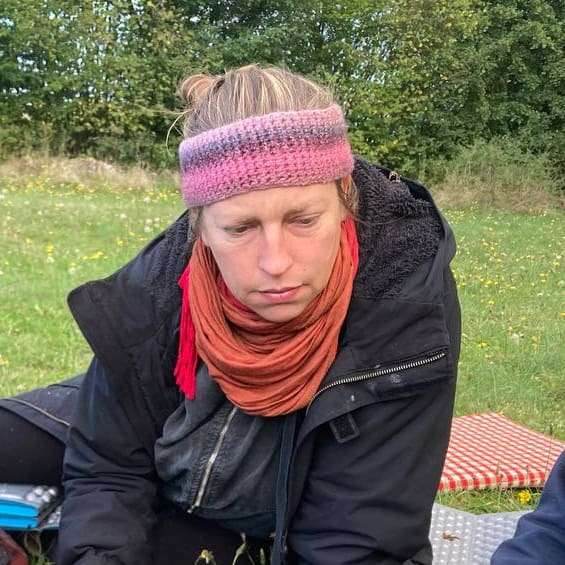 Porträt einer lächelnden Frau namens Tabea mit Kapuze im Freien