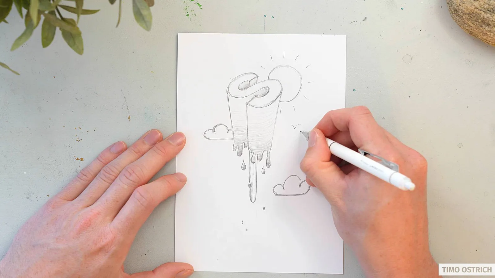 Hände zeichnen buntes Buchstaben-Eis mit Schriftzug auf weißem Papier