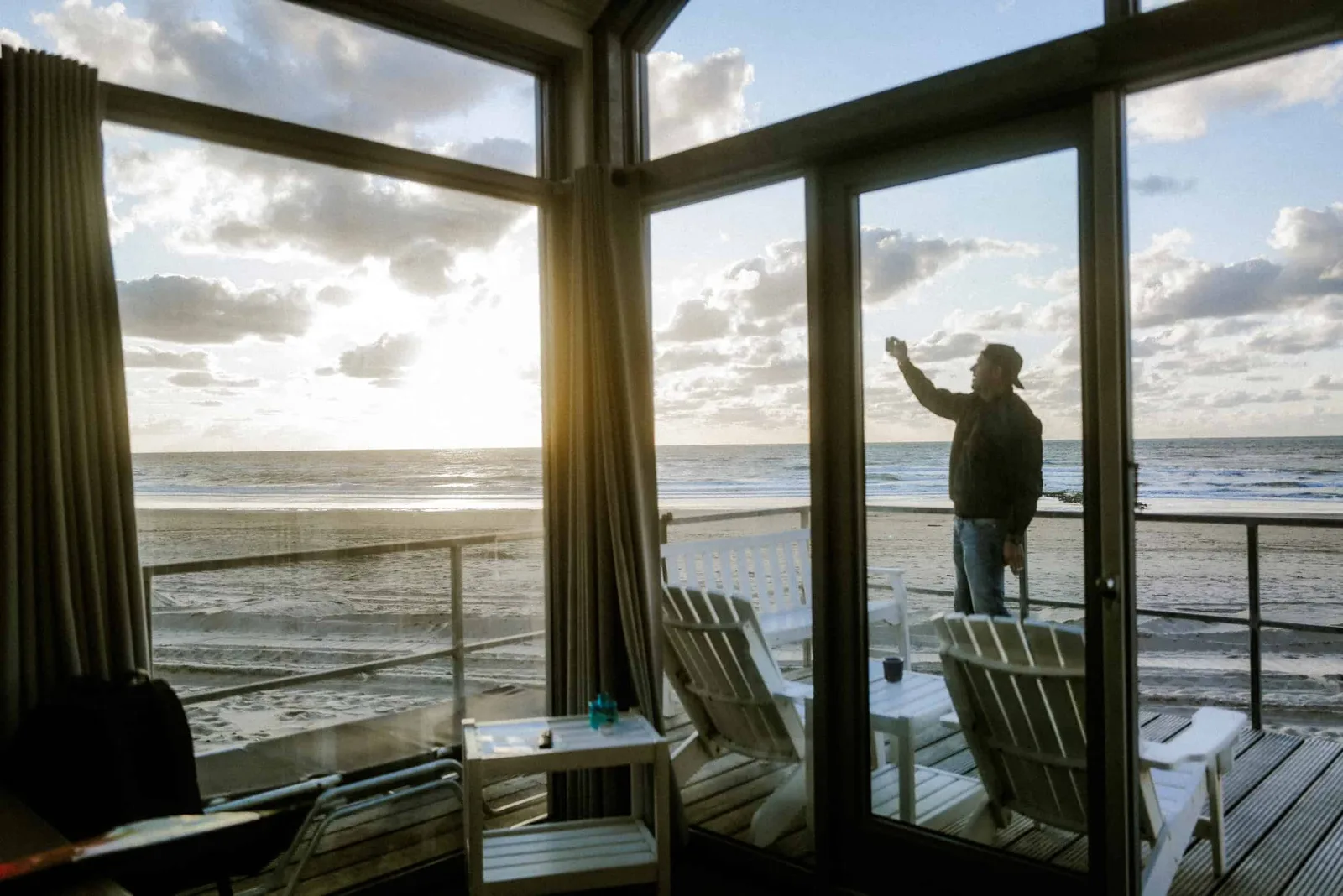 Person an Fenster mit Strandblick demonstriert Lichtkompetenz in natürlicher Umgebung
