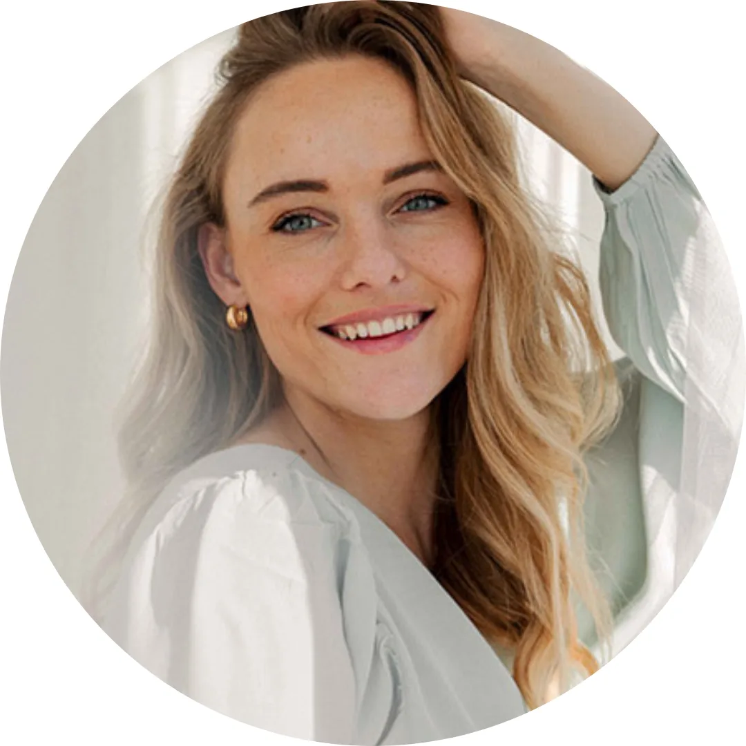Nike Menzel Portrait – Frau mit braunem Haar lächelnd in hellem Shirt vor hellem Hintergrund