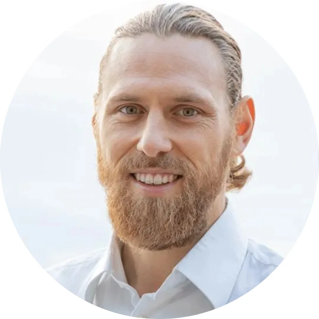 Felix van Frieden, Mann mit Bart und grauem Haar in weißem Hemd, freundliches Lächeln