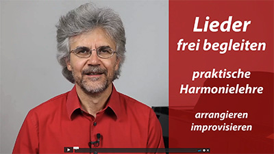 Franz Titscher, Klavierlehrer in rotem Hemd, präsentiert Kurs zu Liedbegleitung und Harmonielehre